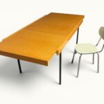 Table à manger extensible ARP Guariche Mortier Motte éditée par Minvielle vers 1960 plaqué frêne piètement métal laqué noir